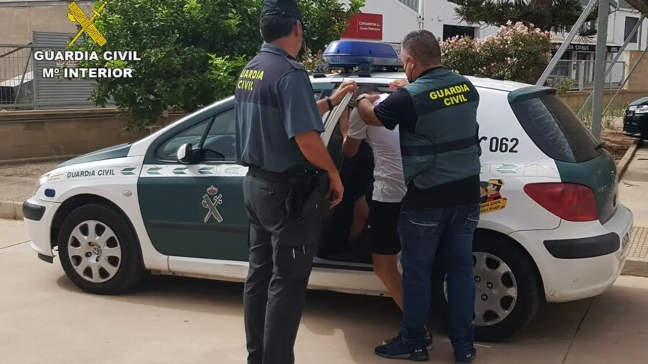 El detenido es introducido en el coche policial