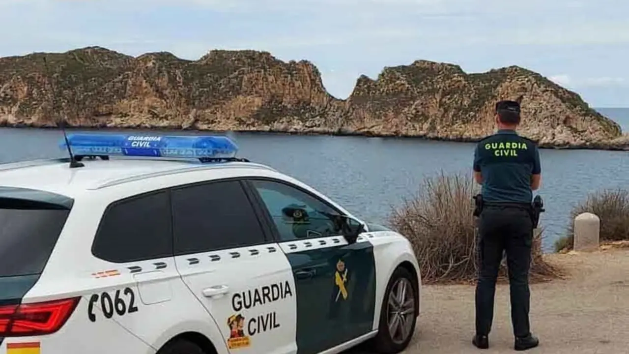 Coche patrulla y agente de la Guardia Civil
