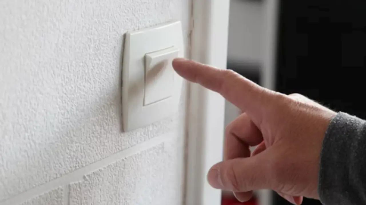 Una persona se dispone a apagar la luz de su casa.