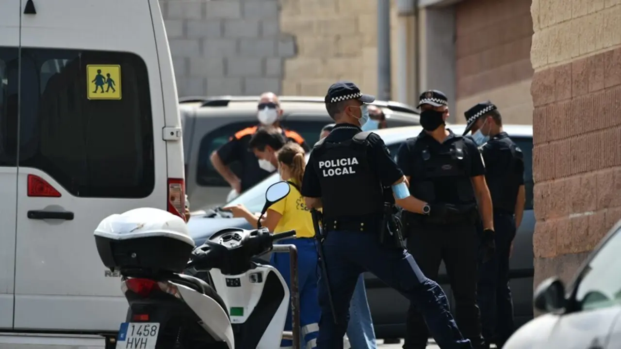 Varios agentes y veh&iacute;culos de la Polic&iacute;a Local de Ceuta acompa&ntilde;an a menores no acompa&ntilde;ados hacia una furgoneta, en las inmediaciones del Polideportivo Santa Amelia, donde fueron acogidos 250 de los 800 menores que llegaron a Ceuta el pasado mes de mayo