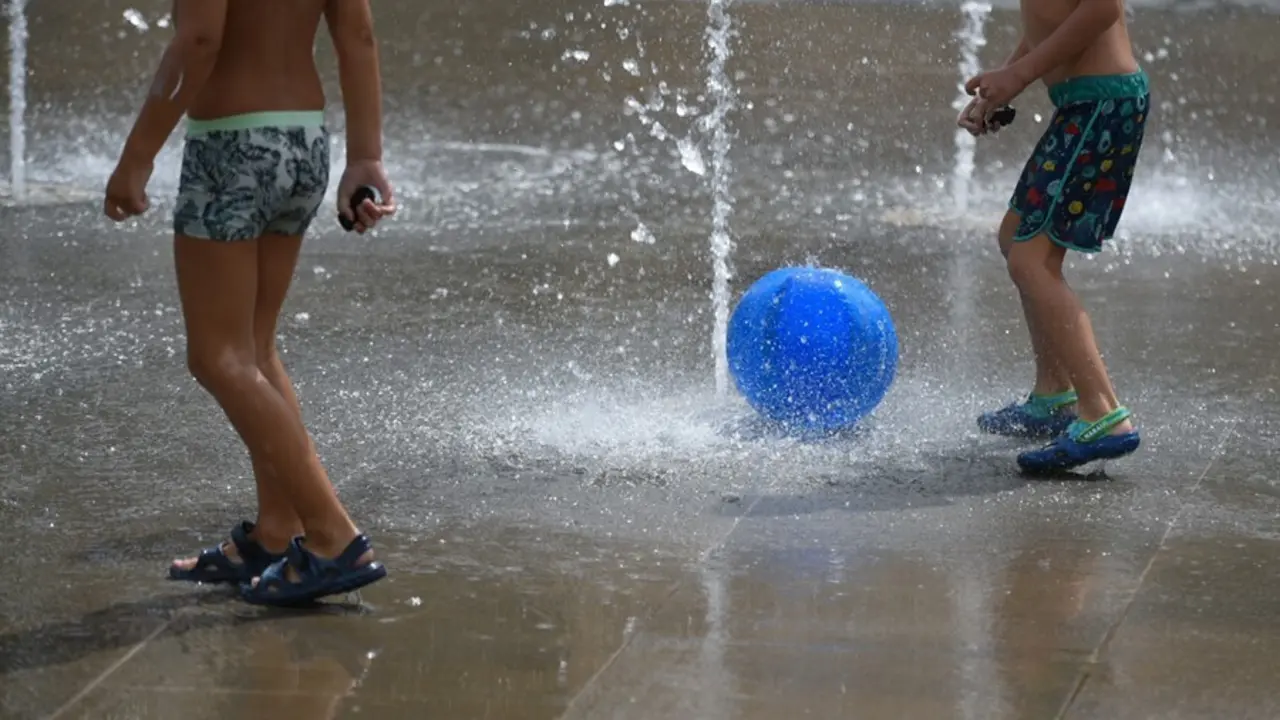 Dos ni&ntilde;os juegan en una fuente del Parc Central, a 12 de agosto de 2021, en Valencia, Comunidad Valenciana (Espa&ntilde;a)