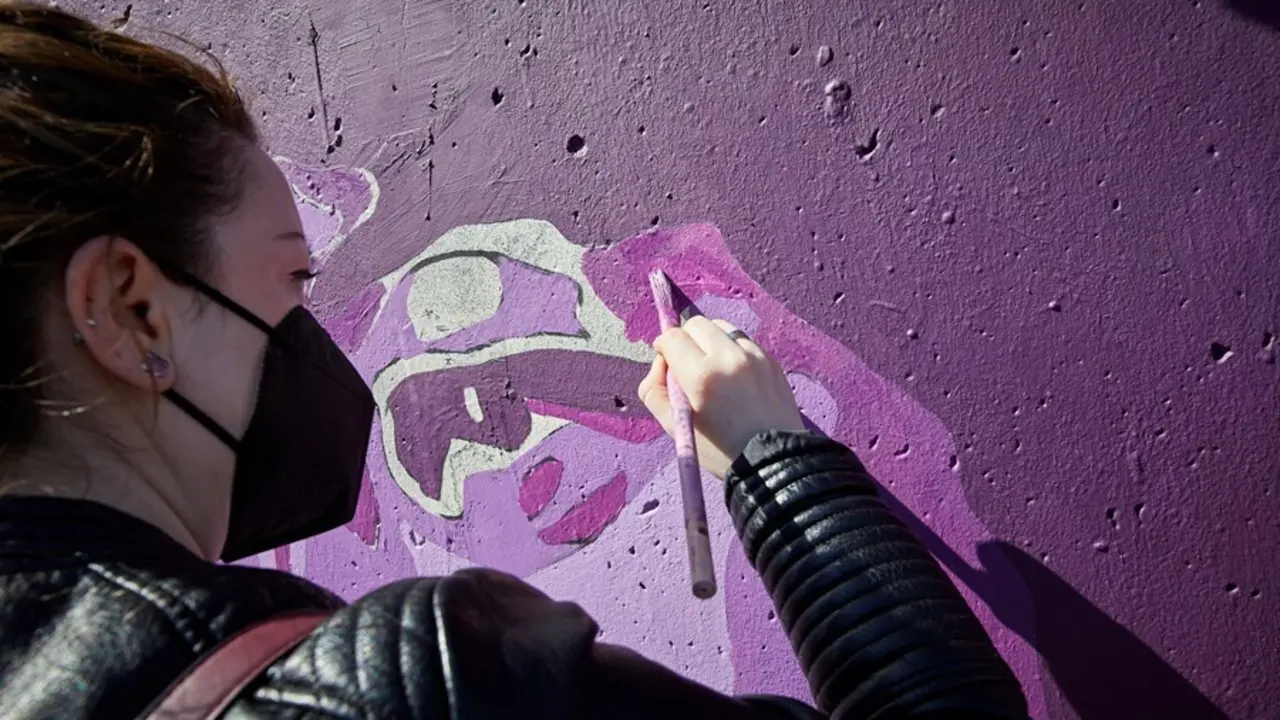 Archivo - Una mujer participa en la tarea de pintar de nuevo el mural feminista de Unlogic Crew en Getafe.
