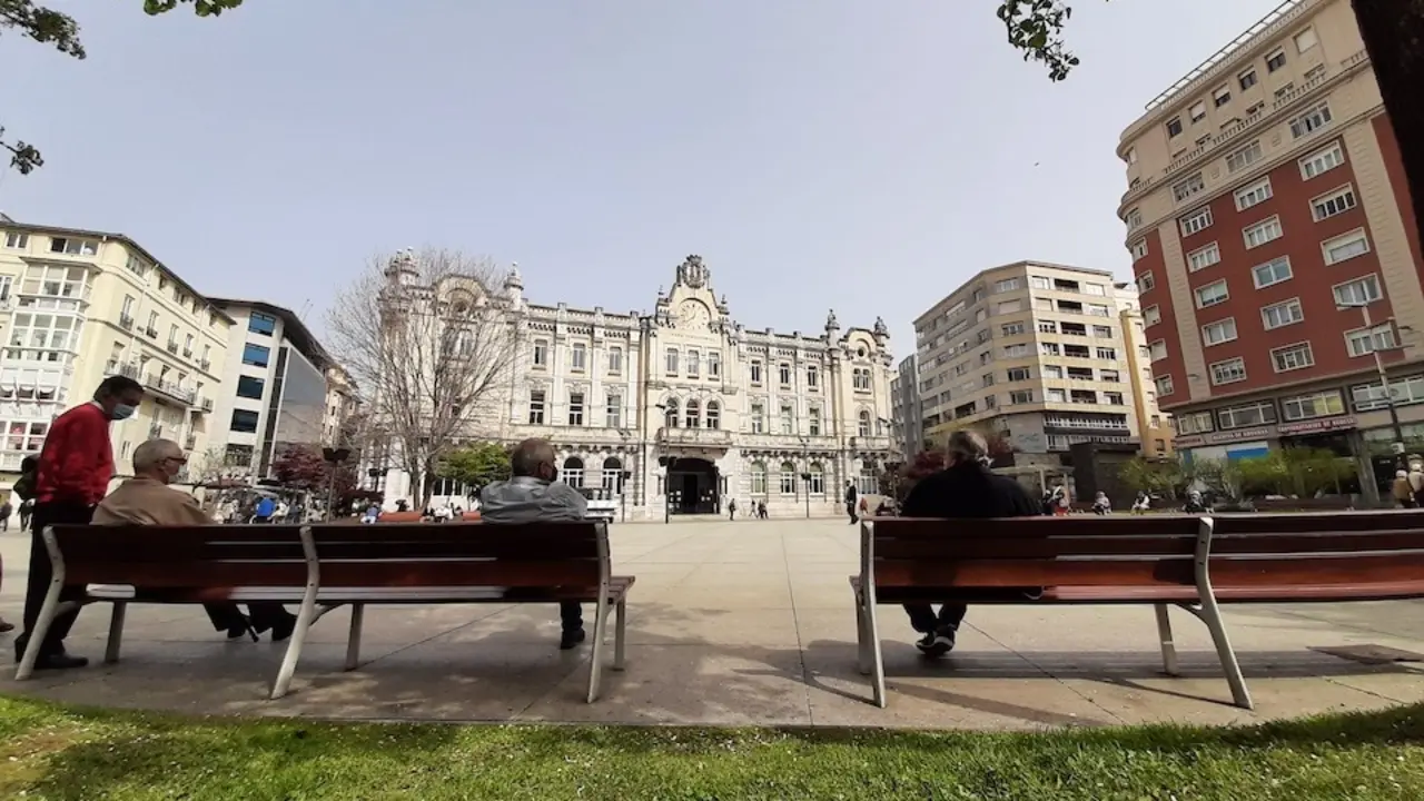 Varias personas sentadas en la plaza del Ayuntamiento de Santander. / S. D&iacute;az