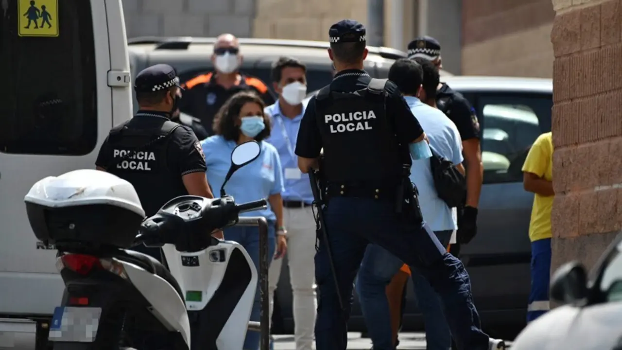 Varios agentes y veh&iacute;culos de la Polic&iacute;a Local de Ceuta acompa&ntilde;an a menores no acompa&ntilde;ados hacia una furgoneta para ser traslados a Marruecos