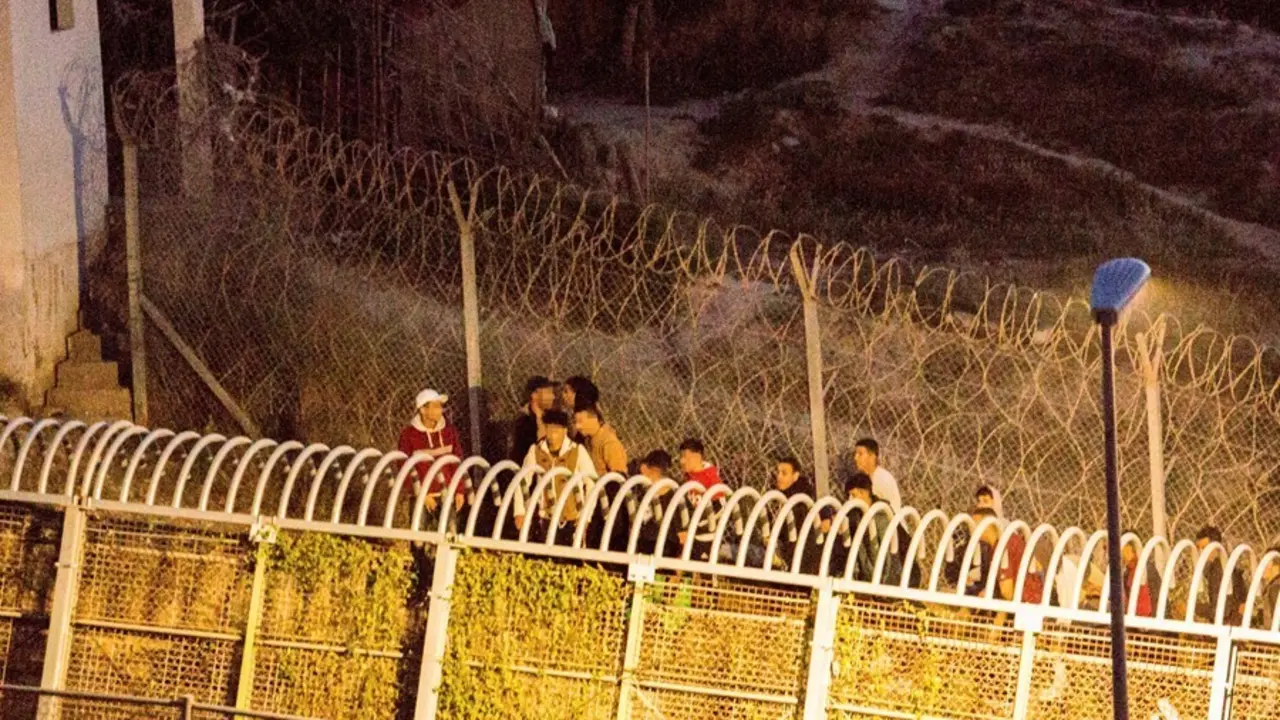 Archivo - Varios marroqu&iacute;es intentan llegar a suelo espa&ntilde;ol desde la frontera que separa Melilla y Marruecos