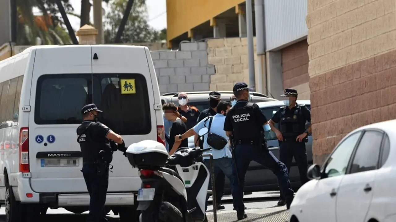 Varios agentes y veh&iacute;culos de la Polic&iacute;a Local de Ceuta acompa&ntilde;an a menores no acompa&ntilde;ados hacia una furgoneta