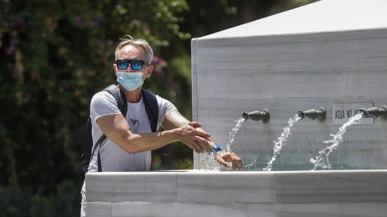 Archivo - Un hombre se refresca en una fuente durante la ola de calor africano que ha llegado este jueves a Espa&ntilde;a. En Sevilla (Andaluc&iacute;a, Espa&ntilde;a), a 30 de julio de 2020.