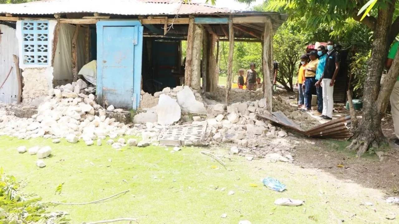 Varias personas observan los da&ntilde;os causados en un edificio tras el terremoto en Hait&iacute;