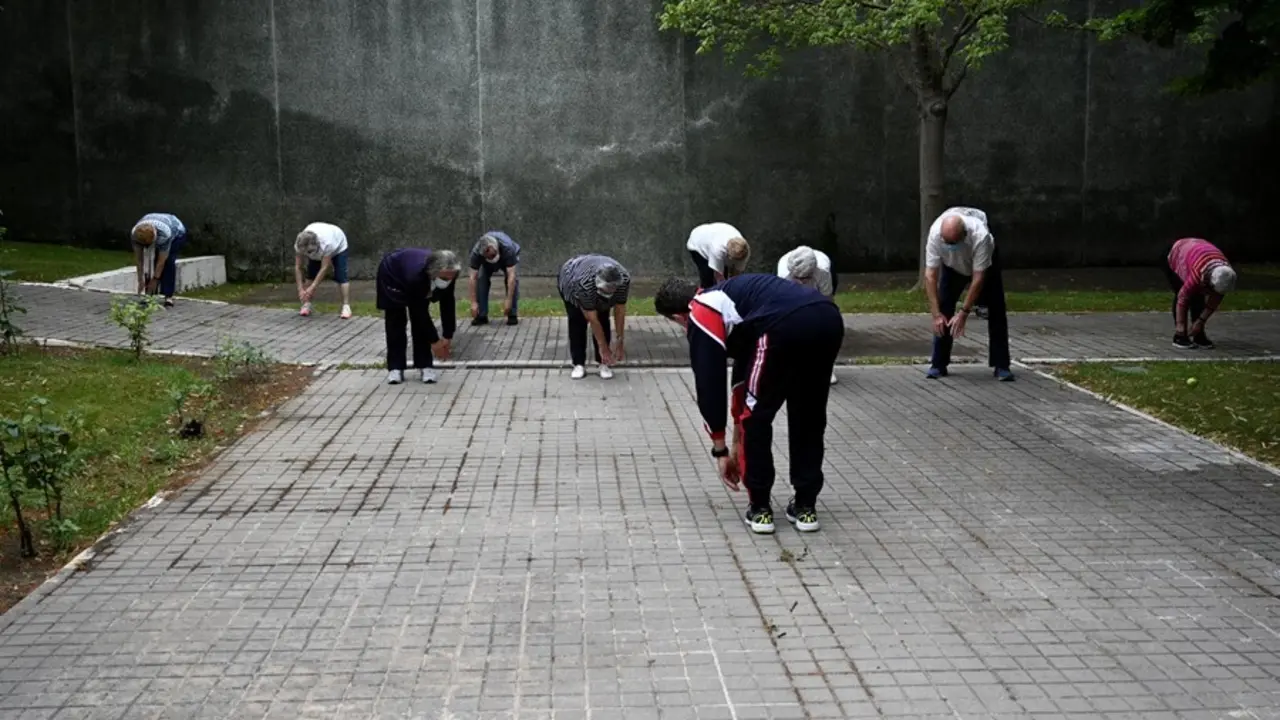 Archivo - Un grupo de ancianos realiza ejercicio en el jard&iacute;n de un centro de d&iacute;a de personas mayores 