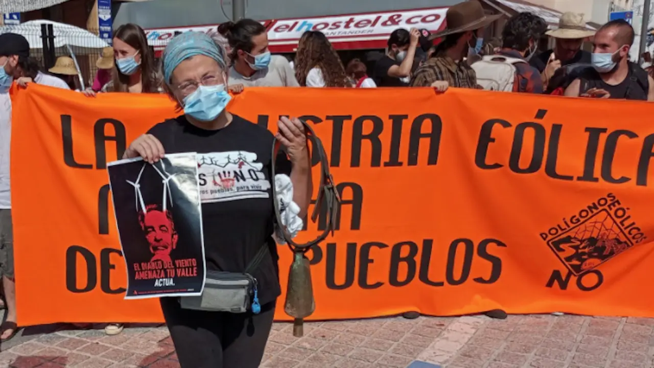 Una persona sostiene un cartel que dice: "El Diablo del viento amenaza tu valle' y sale la imagen de Revilla. / @DPasiegos