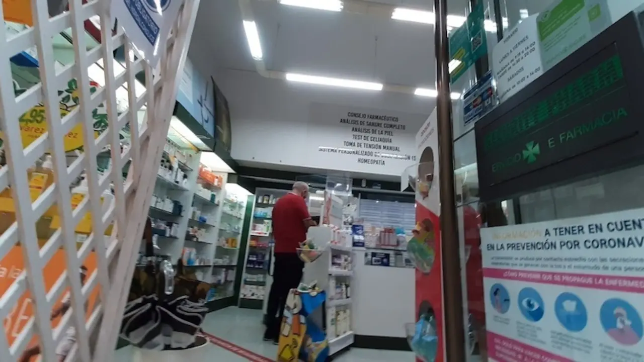 Varias personas en el interior de una farmacia en la calle Escalante de Torrelavega. / S. D&iacute;az