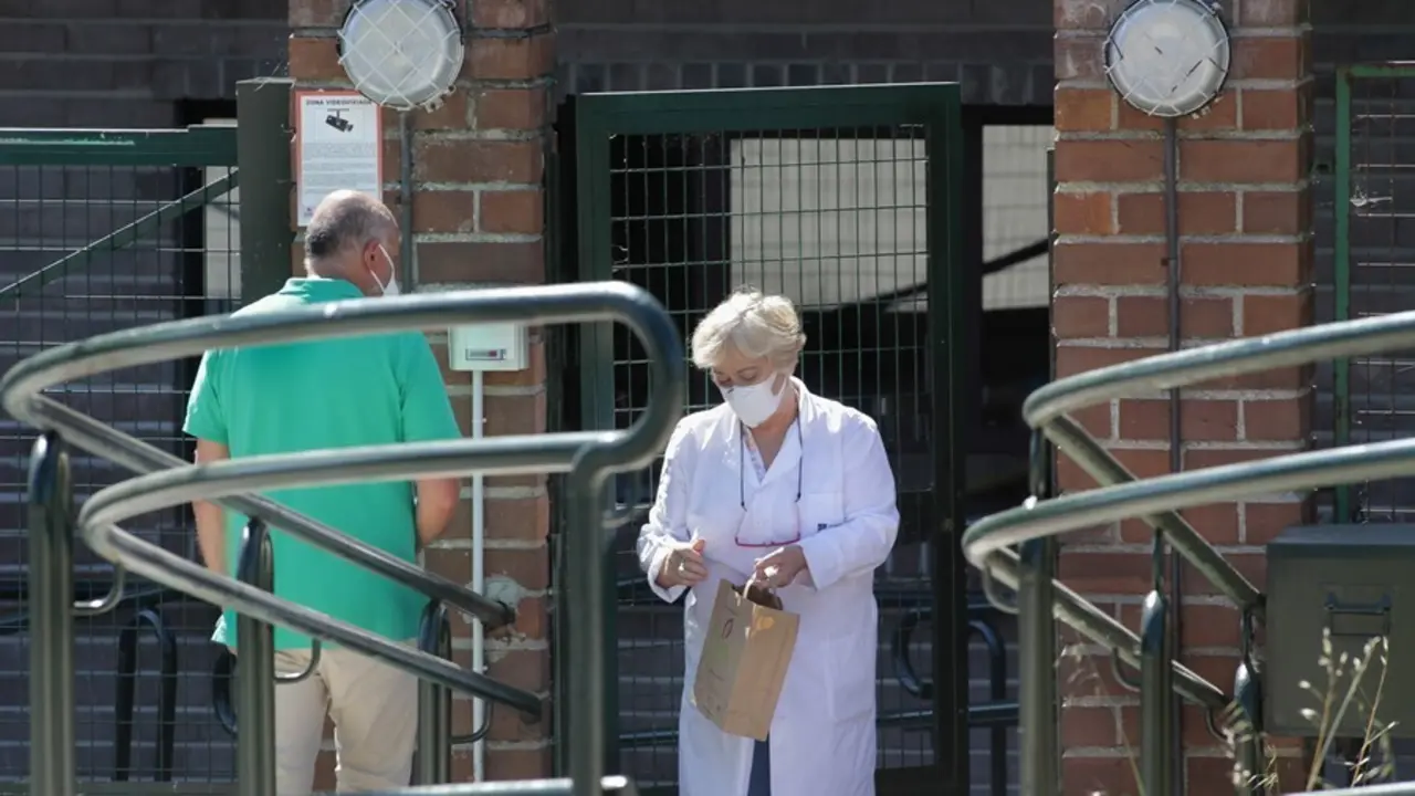 Una trabajadora atiende a un familiar en la puerta de la residencia de As G&aacute;ndaras de Lugo, en agosto de 2021.