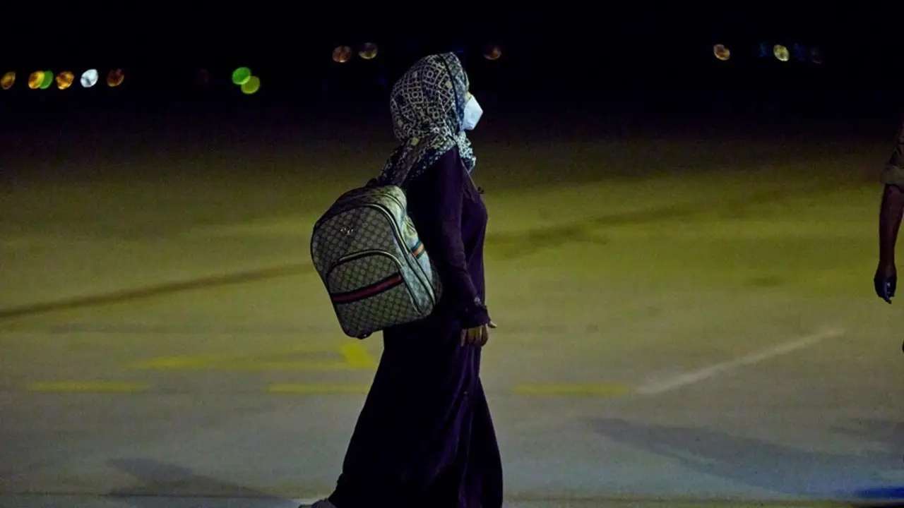 Una mujer repatriada camina a su llegada a la Base A&eacute;rea de Torrej&oacute;n