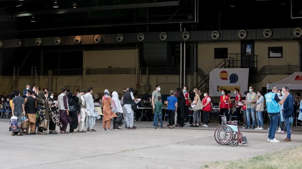 Varios refugiados tras la llegada de un nuevo avi&oacute;n con 260 personas procedentes de Afganist&aacute;n, en la base a&eacute;rea de Torrej&oacute;n de Ardoz