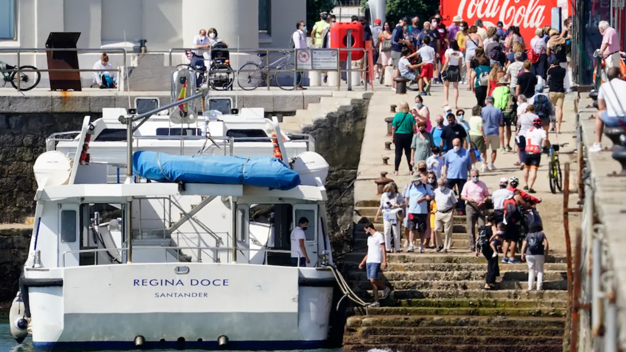 Varias personas se disponen a subir a uno de los barcos en Santander. / Hardy