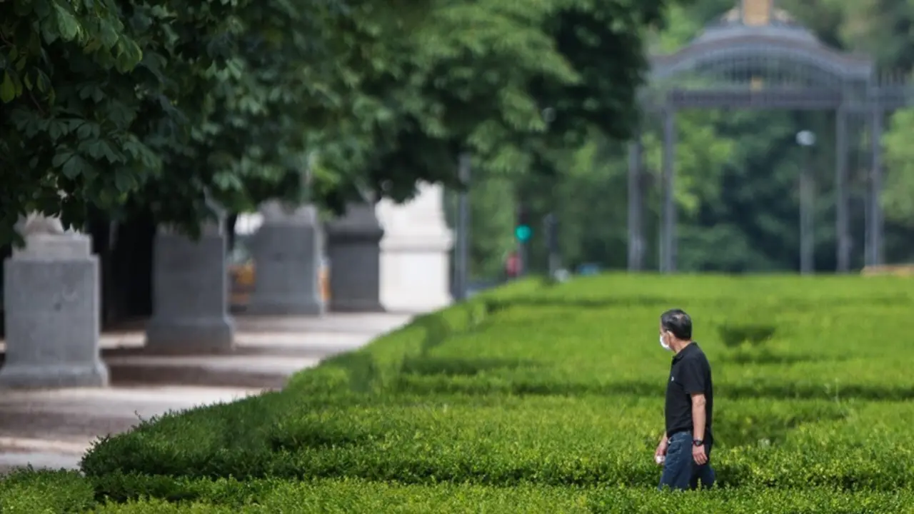 Archivo - Un hombre pasea protegido con mascarilla por el Parque de El Retiro