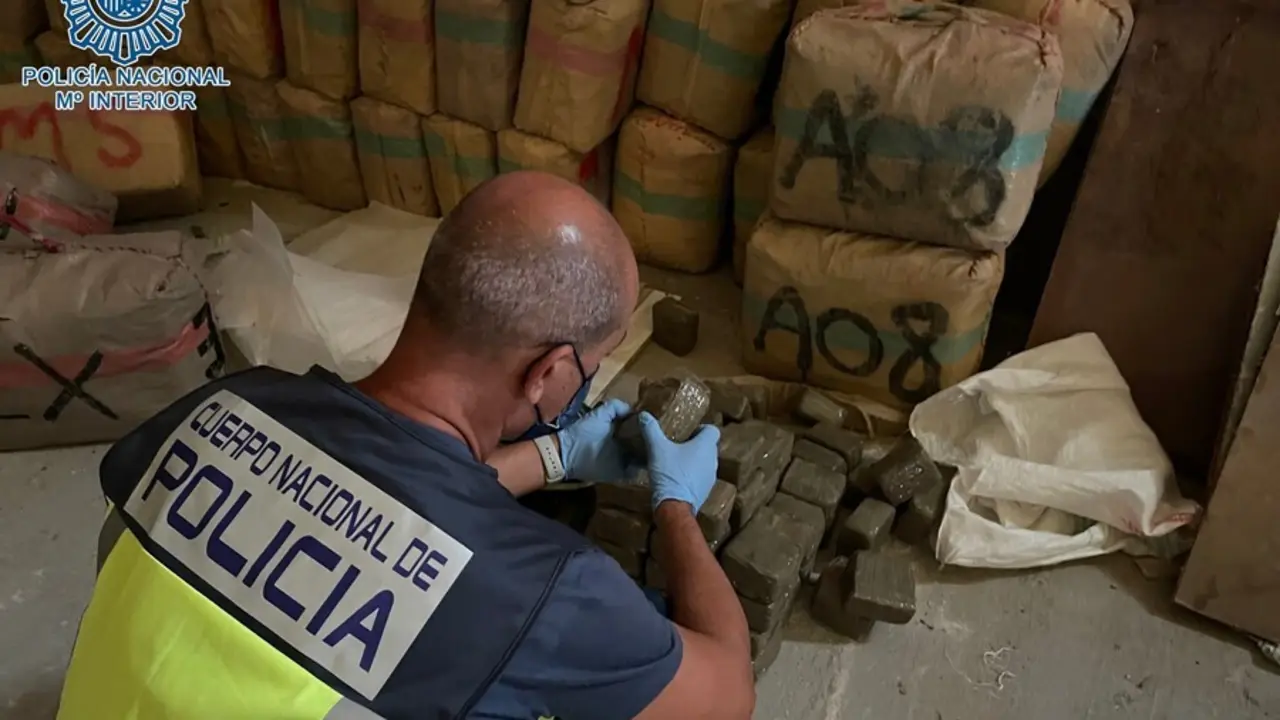Un agente de la Polic&iacute;a comprueba el contenido de los fardos hallados en una nave de Dos Hermanas