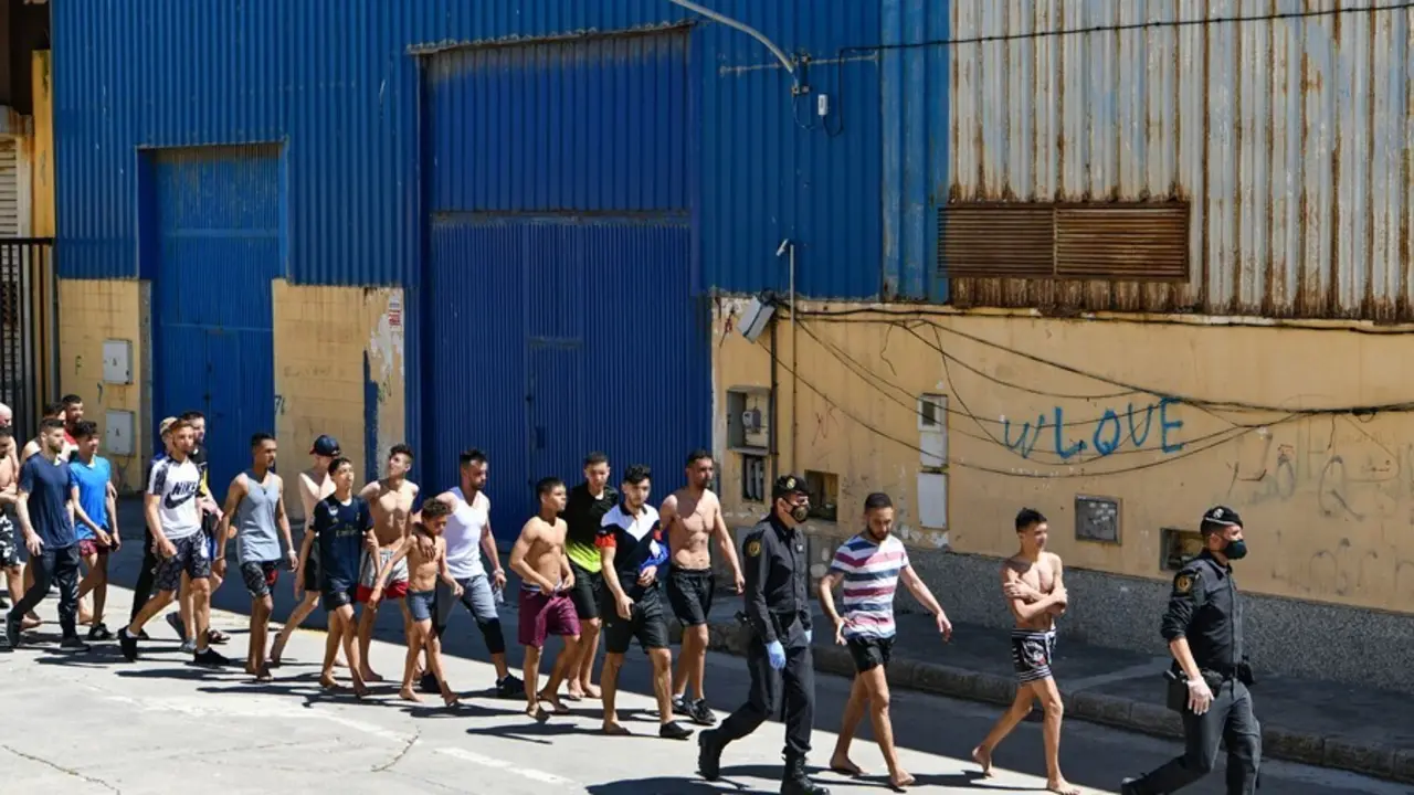 Archivo - Un grupo de j&oacute;venes migrantes marroqu&iacute;es en fila en las inmediaciones de una nave, a 17 de mayo de 2021, en Ceuta (Espa&ntilde;a). La delegaci&oacute;n ha cifrado que unas 1000 personas, de las que al menos 300 son menores de edad, han conseguido sortear los 