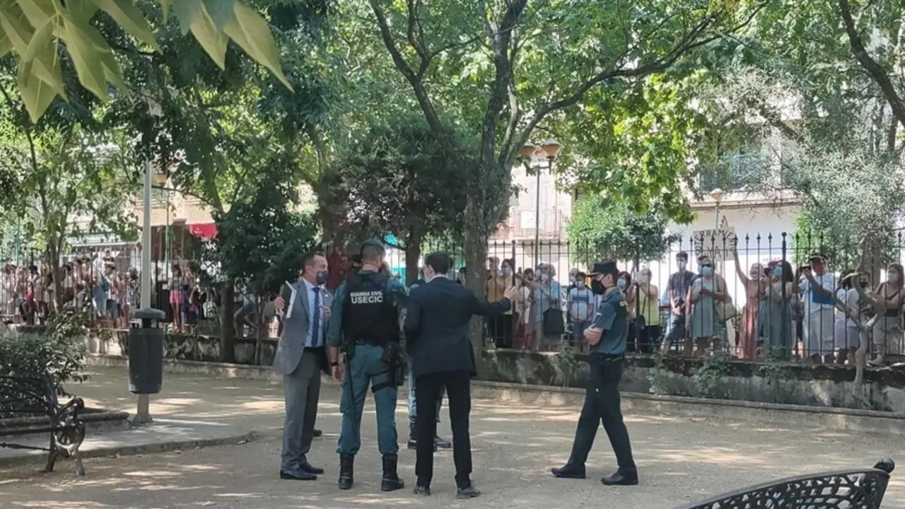 Miembros de las fuerzas de seguridad en el parque Casto Lozano de Navalmoral , frente a los vecinos que aguardan tras las vallas.