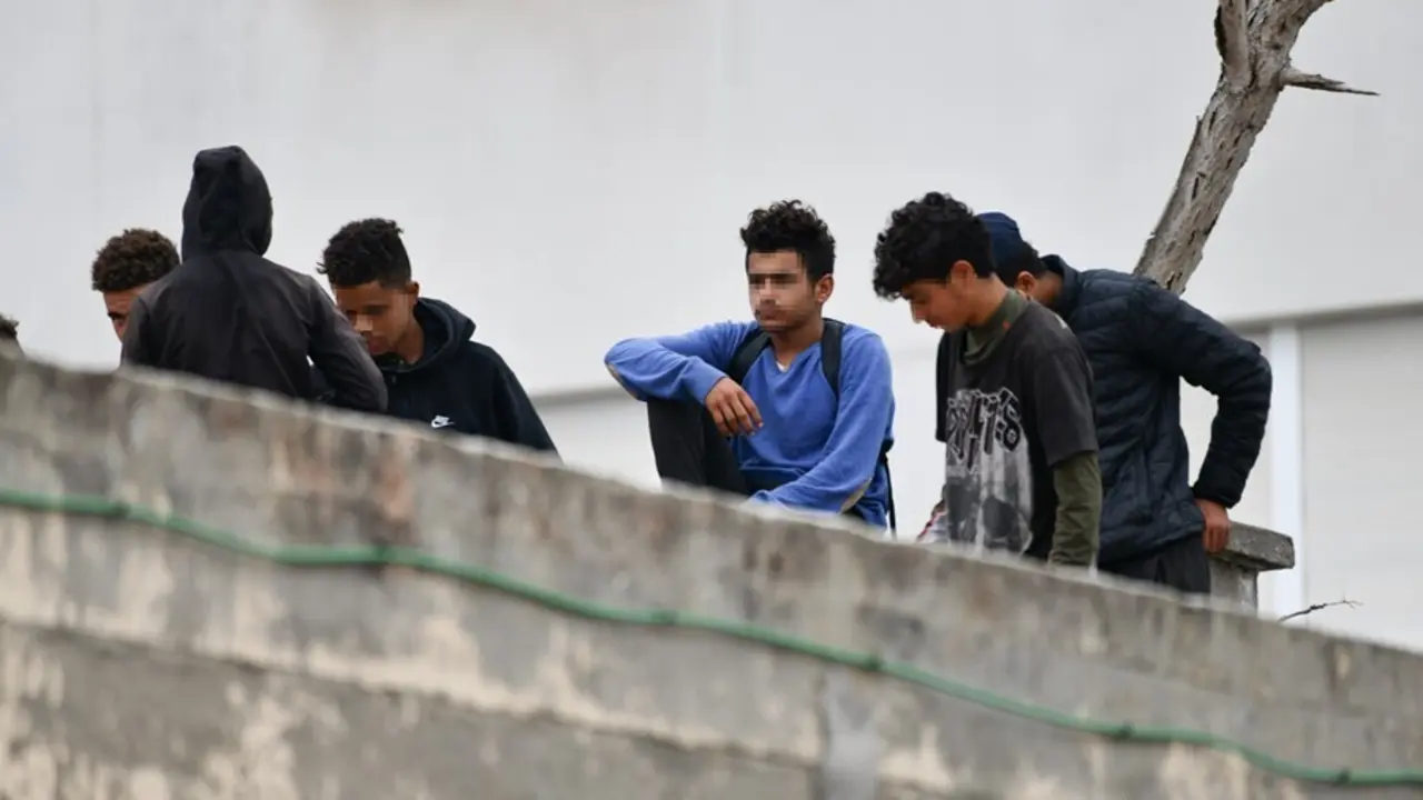 Varios menores migrantes, en el tejado de una nave industrial, a 27 de agosto de 2021, en Ceuta, (Espa&ntilde;a). La Polic&iacute;a Nacional ha desalojado a varios menores que se encontraban en el tejado de esta vieja nave industrial, en la zona portuaria de Ceuta.