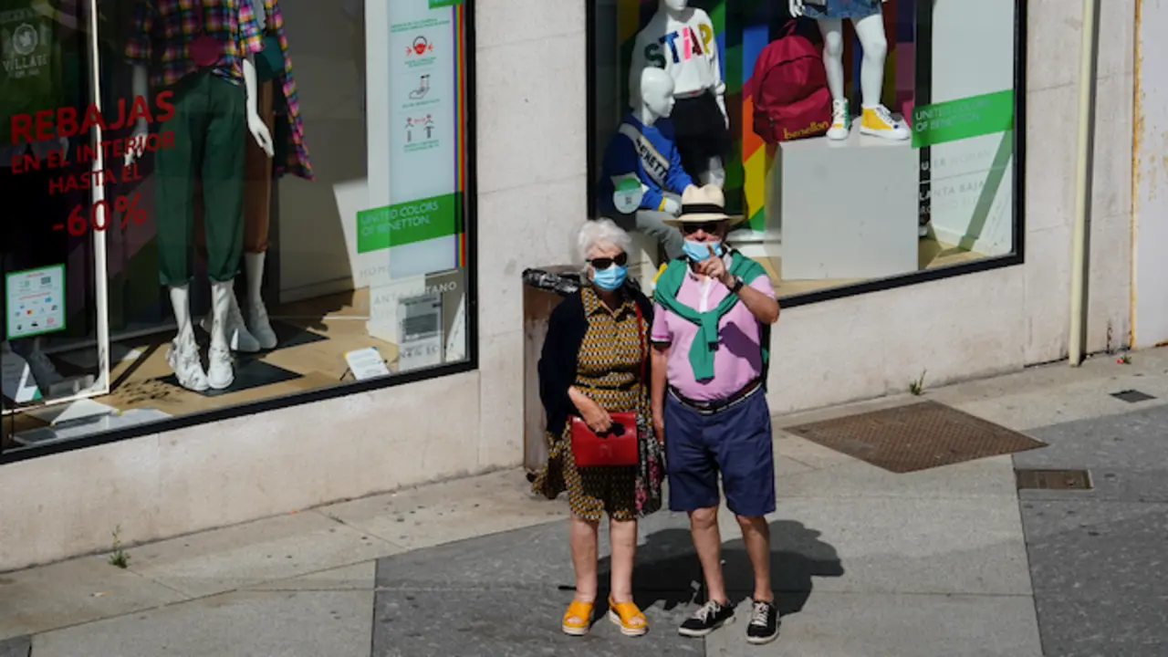 Dos personas transitan con sus mascarillas por el centro de Santander. / Hardy