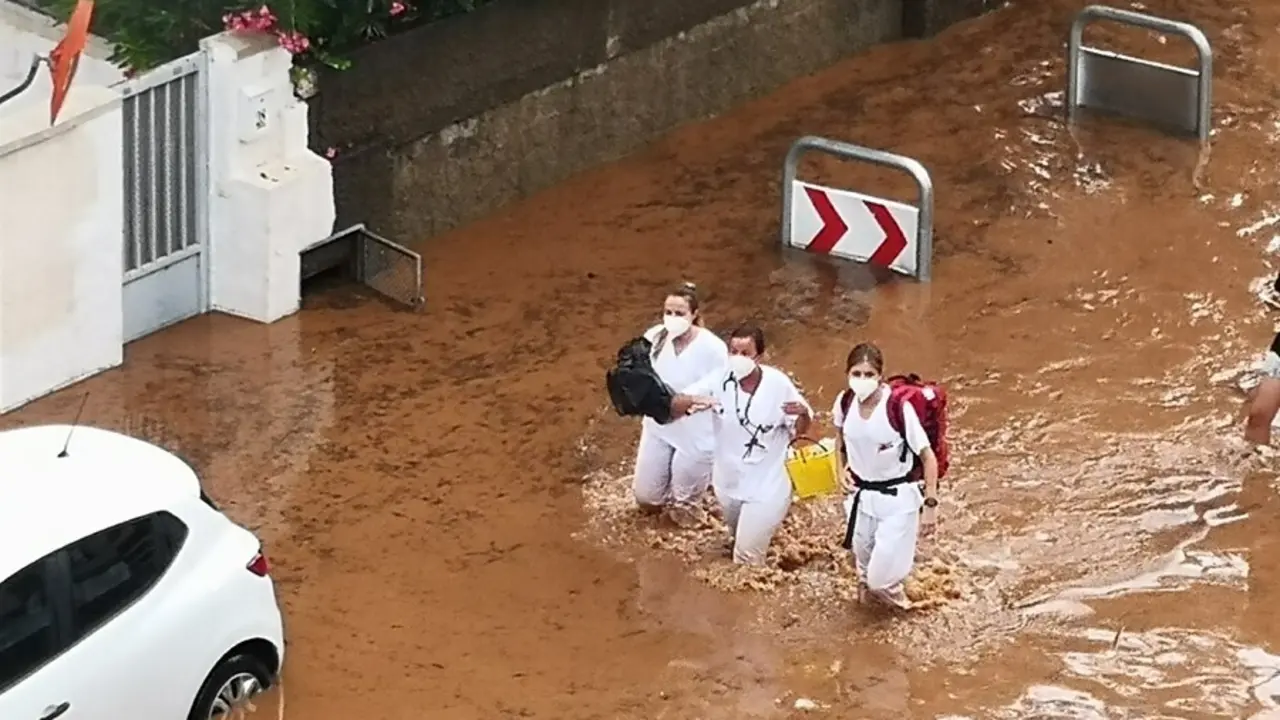 Tres sanitarias atraviesan una calle inundada este domingo en Benic&agrave;ssim (Castell&oacute;n)