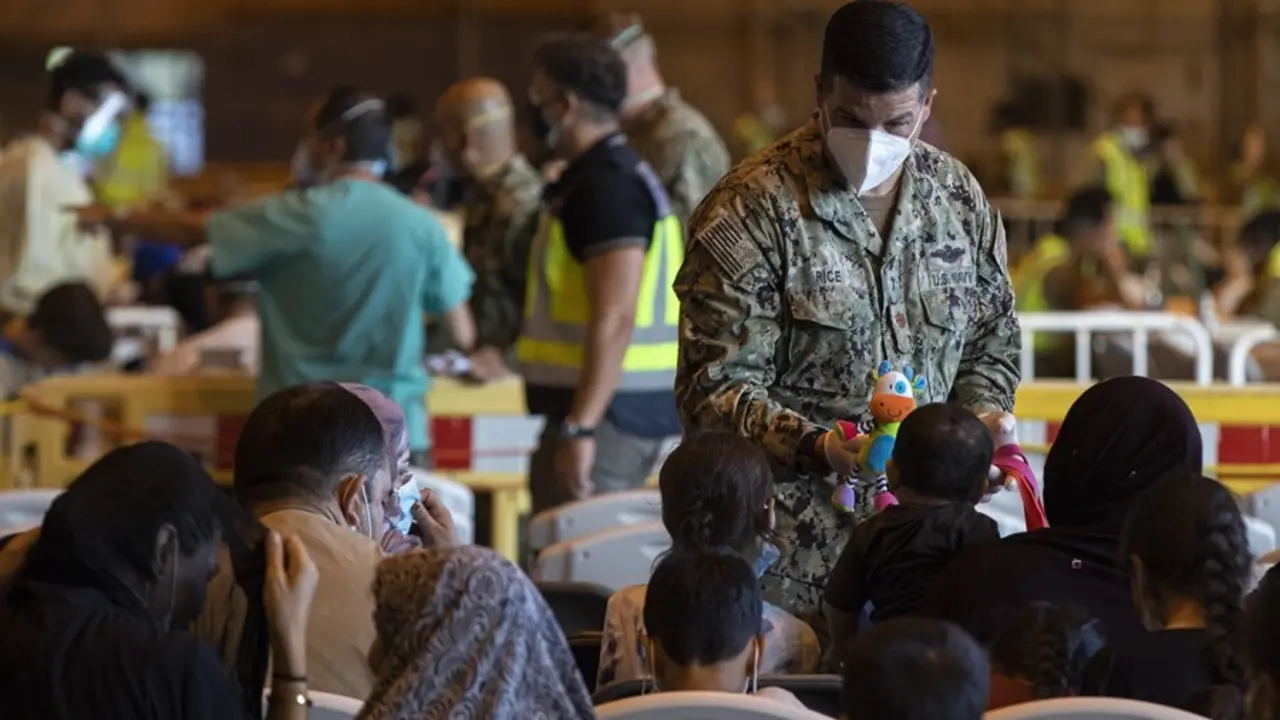 Un militar de Estados Unidos ofrece un mu&ntilde;eco a un ni&ntilde;o afgano en la Base Naval de Rota.