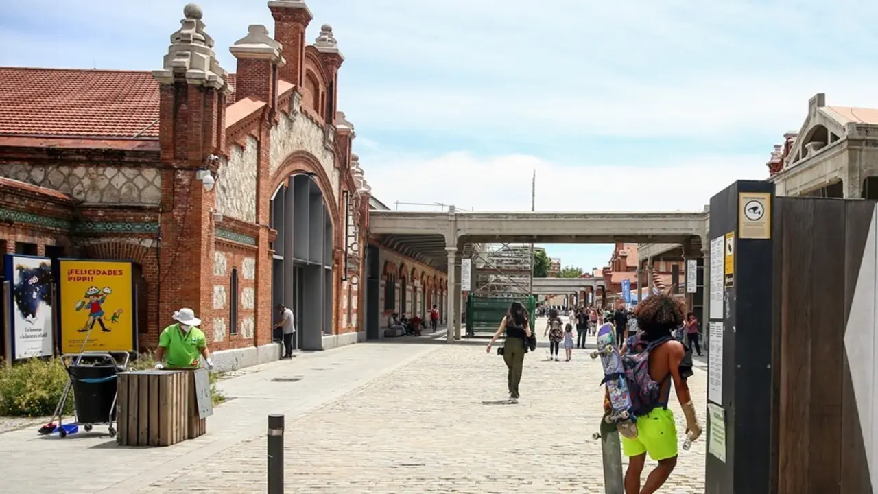 Archivo - Un hombre camina con varios monopatines en Matadero-Madrid