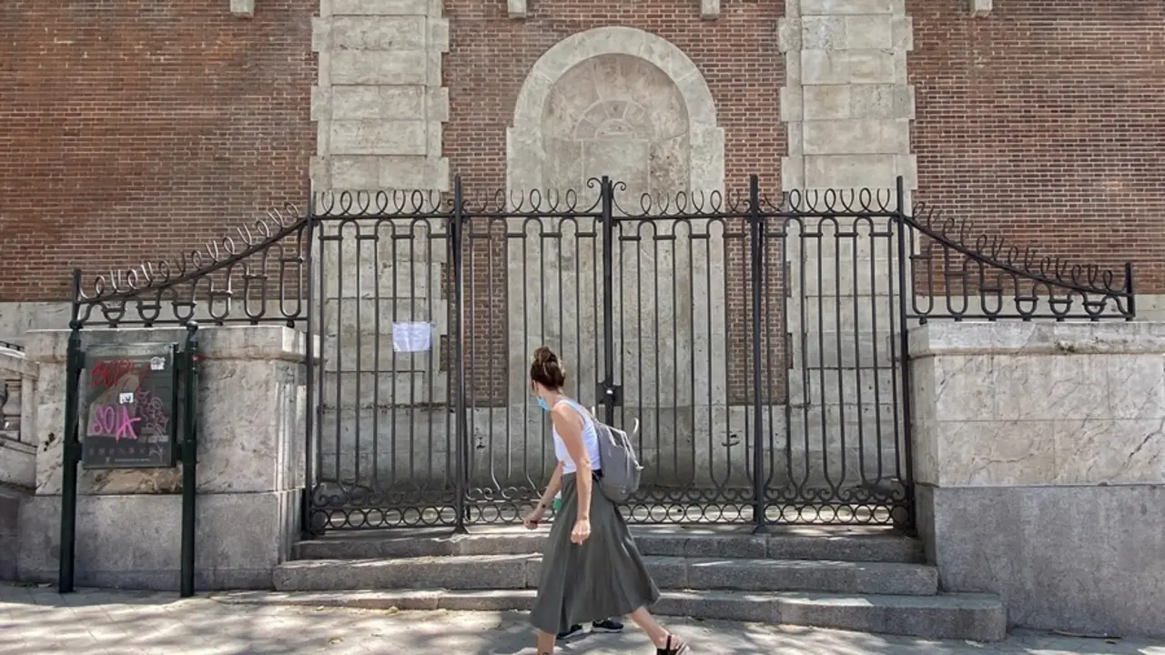 Archivo - Una mujer pasa al lado de una de las puertas de los Jardines de Sabatini