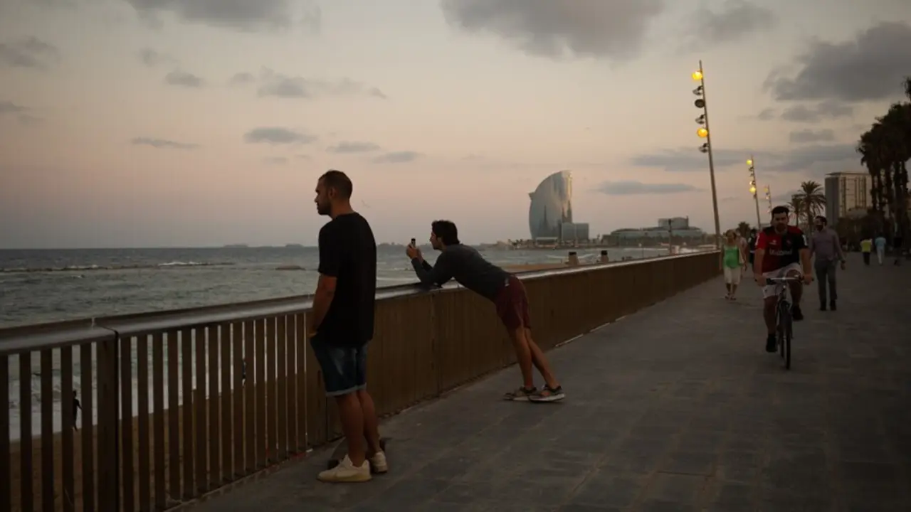 Dos hombres miran el paisaje frente a la playa de la Barceloneta, a 4 de agosto de 2021, en Barcelona, Catalunya (Espa&ntilde;a). 