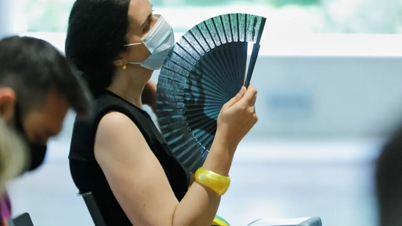 Archivo - Una mujer con mascarilla se abanica en Madrid