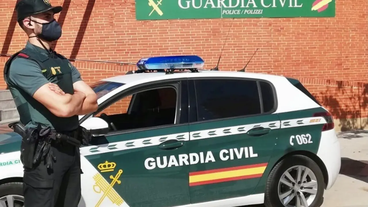 Archivo - Un agente de la Guardia Civil, junto a un veh&iacute;culo del cuerpo.