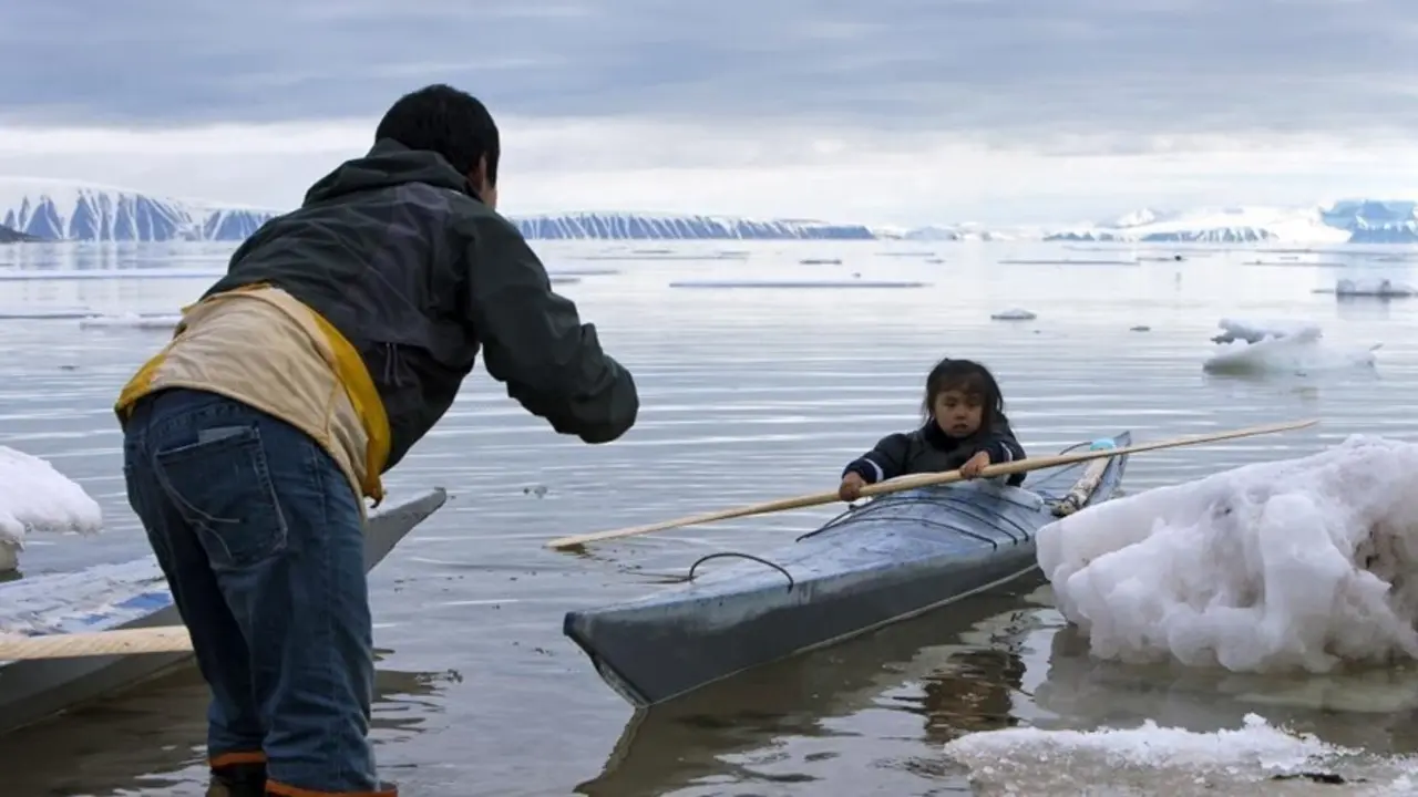 En la foto, un adulto ense&ntilde;a a un ni&ntilde;o a remar cerca de Siorapaluk en el noroeste de Groenlandia.