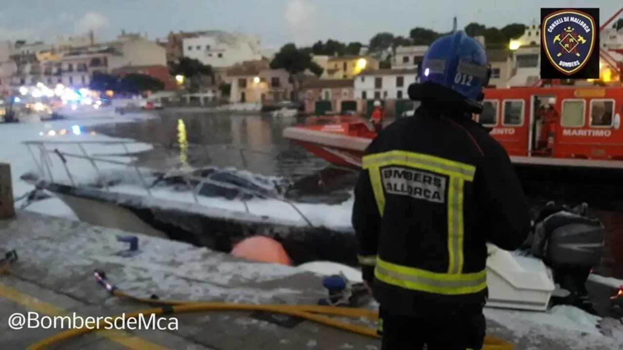 Un bombero frente a la embarcaci&oacute;n incendiada en Portopetro.