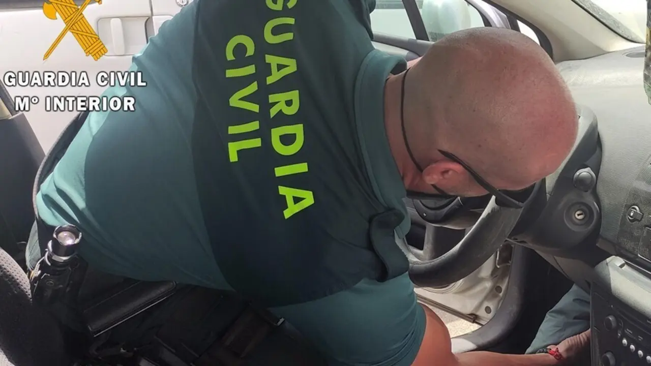 Un agente de la Guardia Civil inspecciona un veh&iacute;culo.