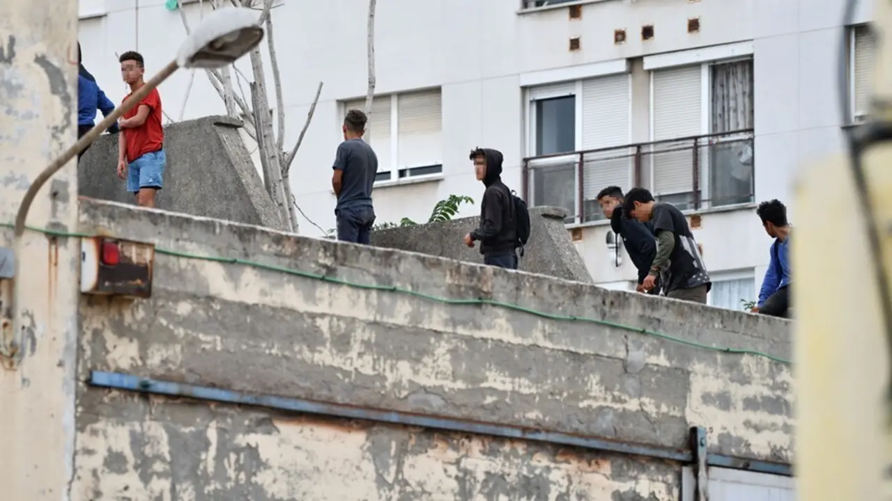 Varios menores migrantes, en el tejado de una nave industrial, a 27 de agosto de 2021, en Ceuta, (Espa&ntilde;a). La Polic&iacute;a Nacional ha desalojado a varios menores que se encontraban en el tejado de esta vieja nave industrial, en la zona portuaria de Ceuta.