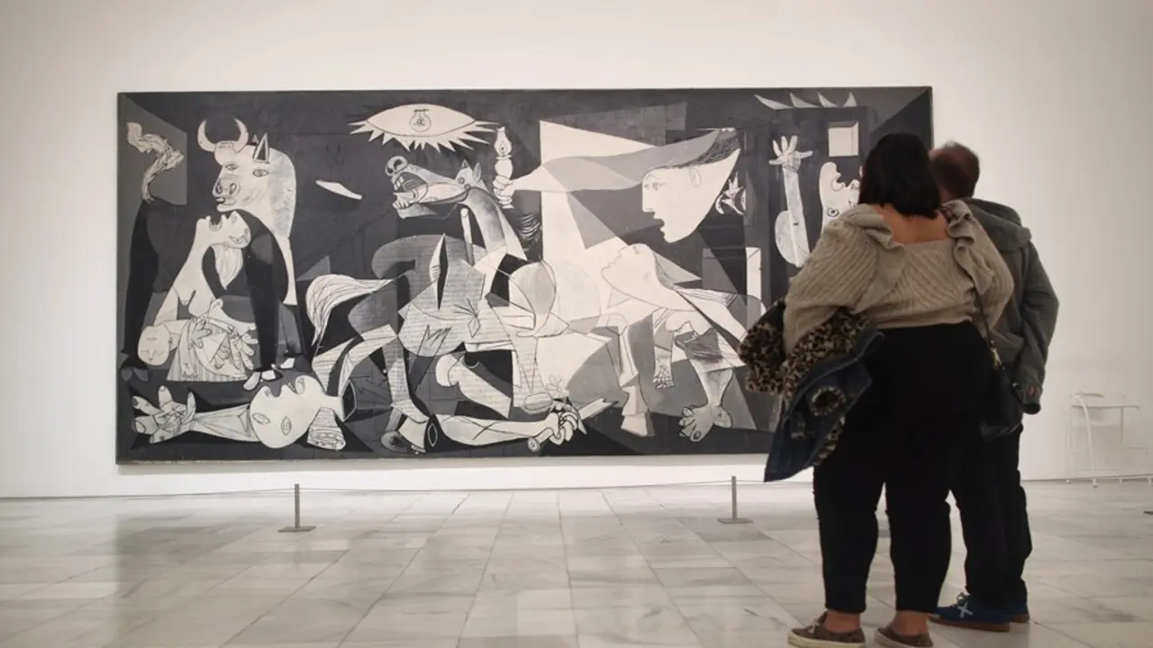 Archivo - Dos personas observan el 'Guernica' de Pablo Picasso en una de las salas del Museo Reina Sof&iacute;a 