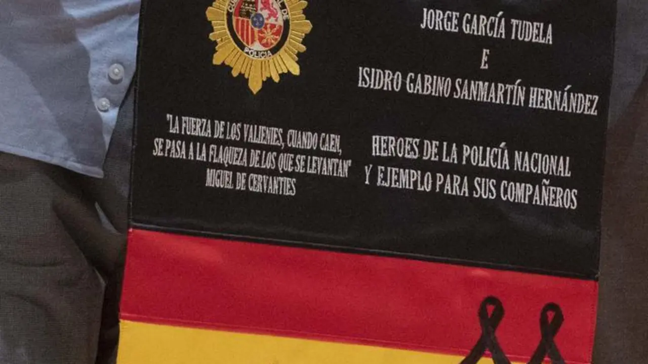 Un familiar de uno de los dos polic&iacute;as ca&iacute;dos en un atentado terrorista en la Embajada de Espa&ntilde;a en Afganist&aacute;n en 2015, sostiene una bandera de Espa&ntilde;a que hab&iacute;a sido custodiada en el pa&iacute;s para recordarlos