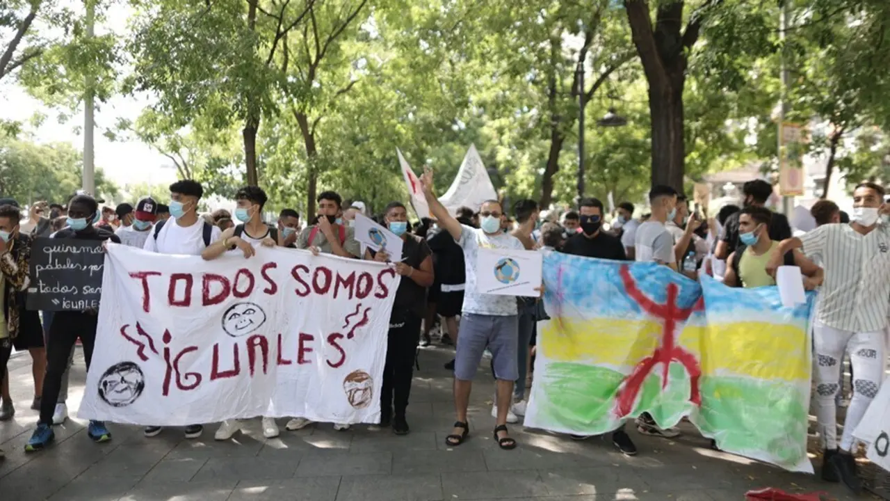 Varias personas con una pancarta en la que se lee: `Todos somos iguales&acute;, en una concentraci&oacute;n frente al Ministerio del Interior para exigir la reforma del Reglamento de Extranjer&iacute;a.