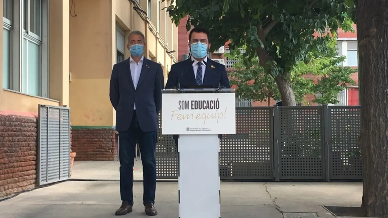 El presidente de la Generalitat, Pere Aragon&egrave;s, y el conseller de Educaci&oacute;n, Josep Gonz&agrave;lez-Cambray (detr&aacute;s), en una rueda de prensa en la Escola Tanit de Santa Coloma de Gramenet (Barcelona) el primer d&iacute;a del curso 2021-2022