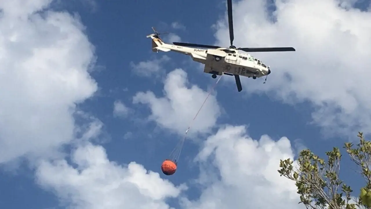 Un helic&oacute;ptero trabaja en la zona del incendio en Sierra Bermeja, al que se incorporan tambi&eacute;n bomberos de m&aacute;laga capital