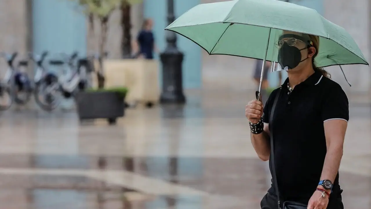 Archivo - Una persona sostiene un paraguas mientras llueve, a 26 de julio de 2021, en Valencia, Comunidad Valenciana, (Espa&ntilde;a). Para esta jornada, con nivel m&aacute;ximo naranja, se espera cielo nuboso que tender&aacute; a intervalos nubosos al final y viento de compo