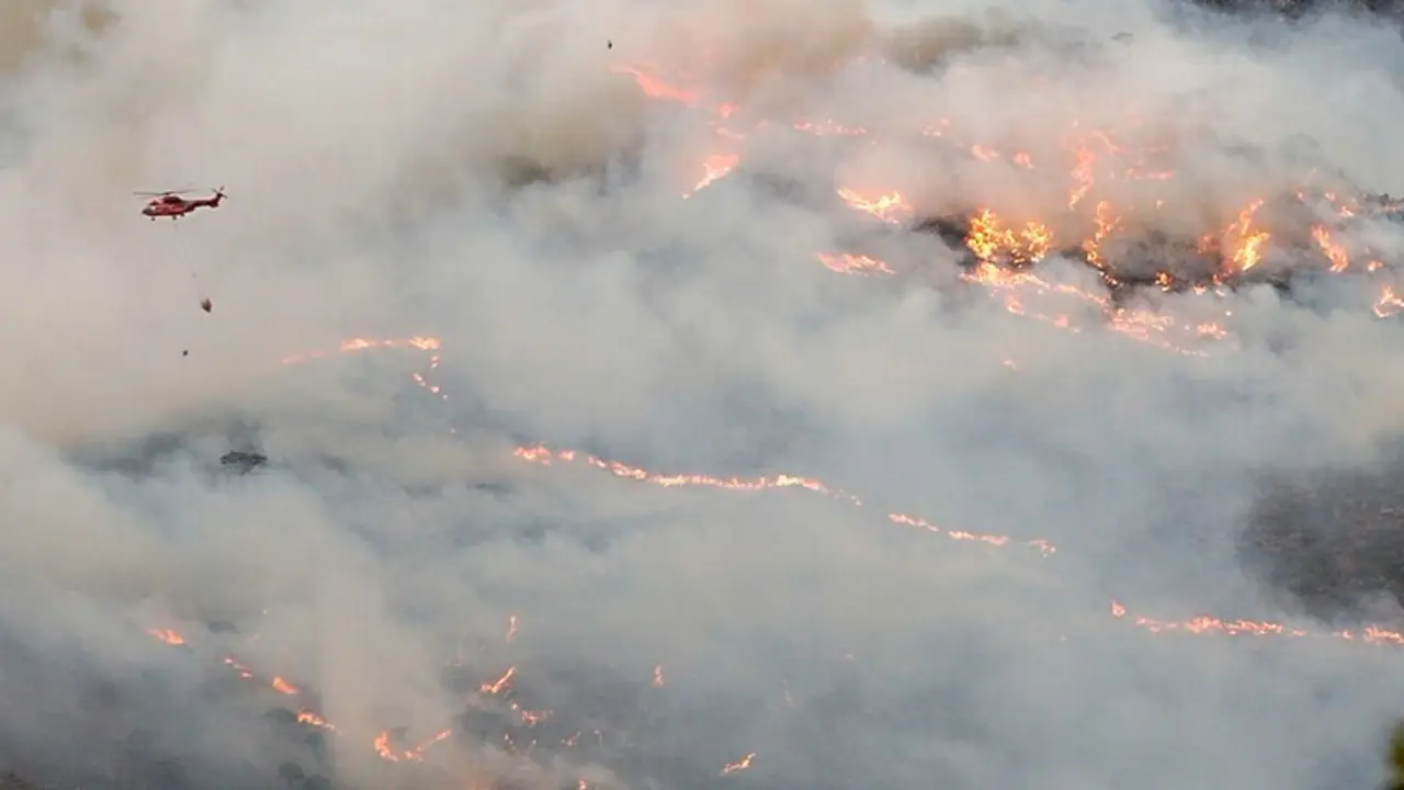 Helic&oacute;ptero contra incendio intentando apagar el fuego de la Sierra Bermeja, visto desde el cerro de la Silla de los Huesos, a 13 de septiembre 2021 en Casares (M&aacute;laga) Andaluc&iacute;a