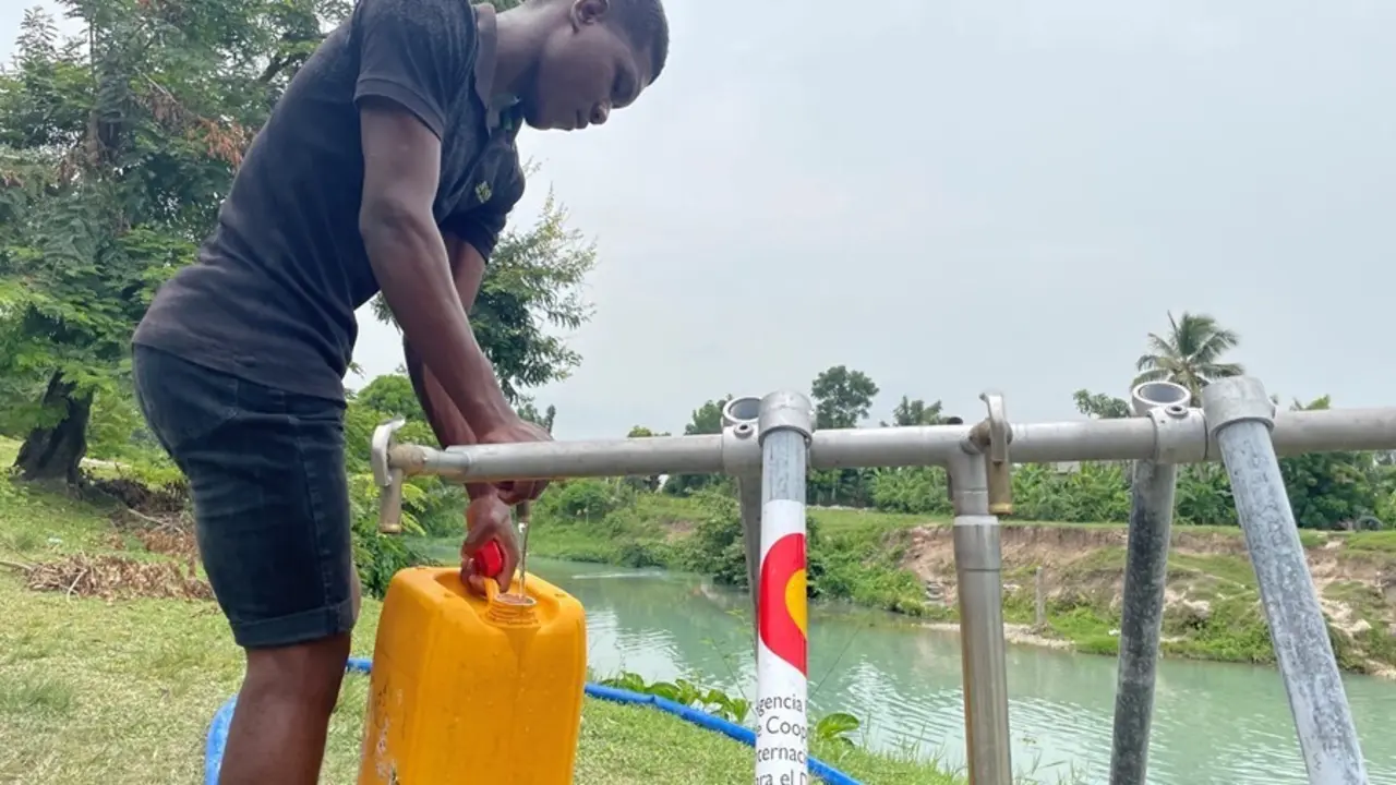 Un hombre en un punto de aprovisionamiento de agua instalado con ayuda de AECID en Hait&iacute;