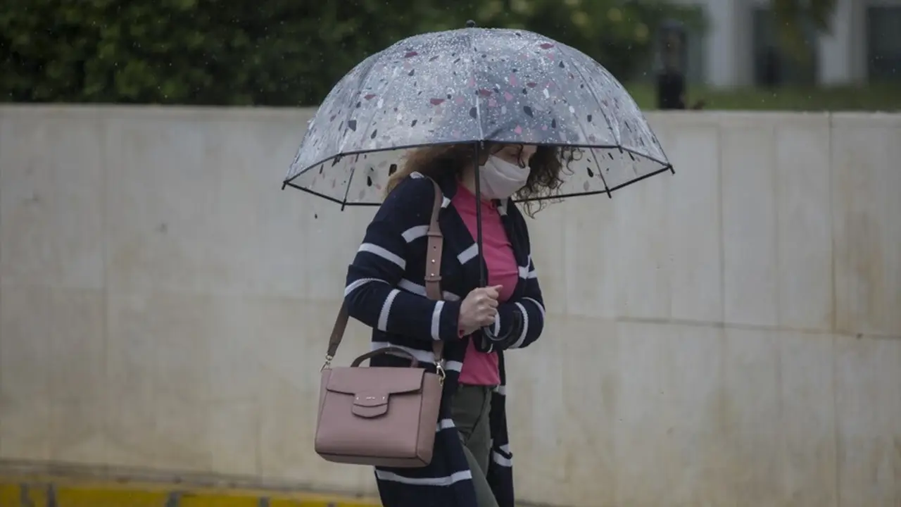 Archivo - Una mujer con paraguas y mascarilla en una imagen de archivo.