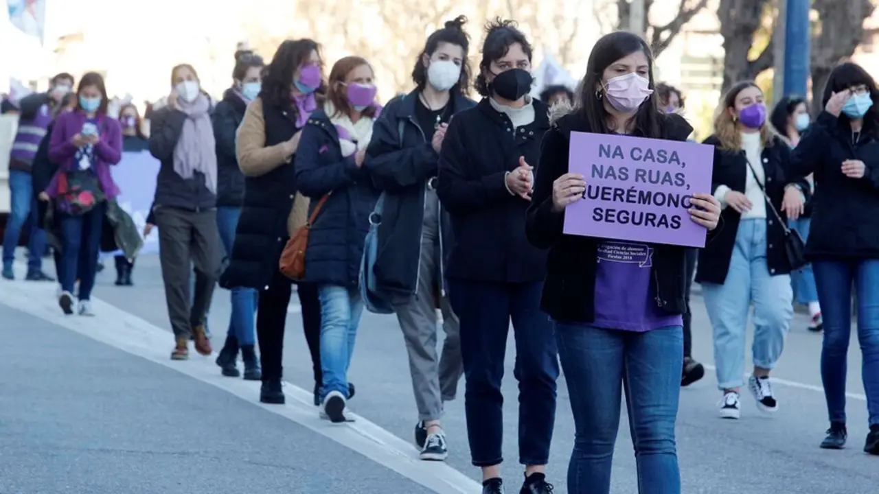 Archivo - Una mujer sostiene una pancarta donde se lee "En casa, en las calles, nos queremos seguras".