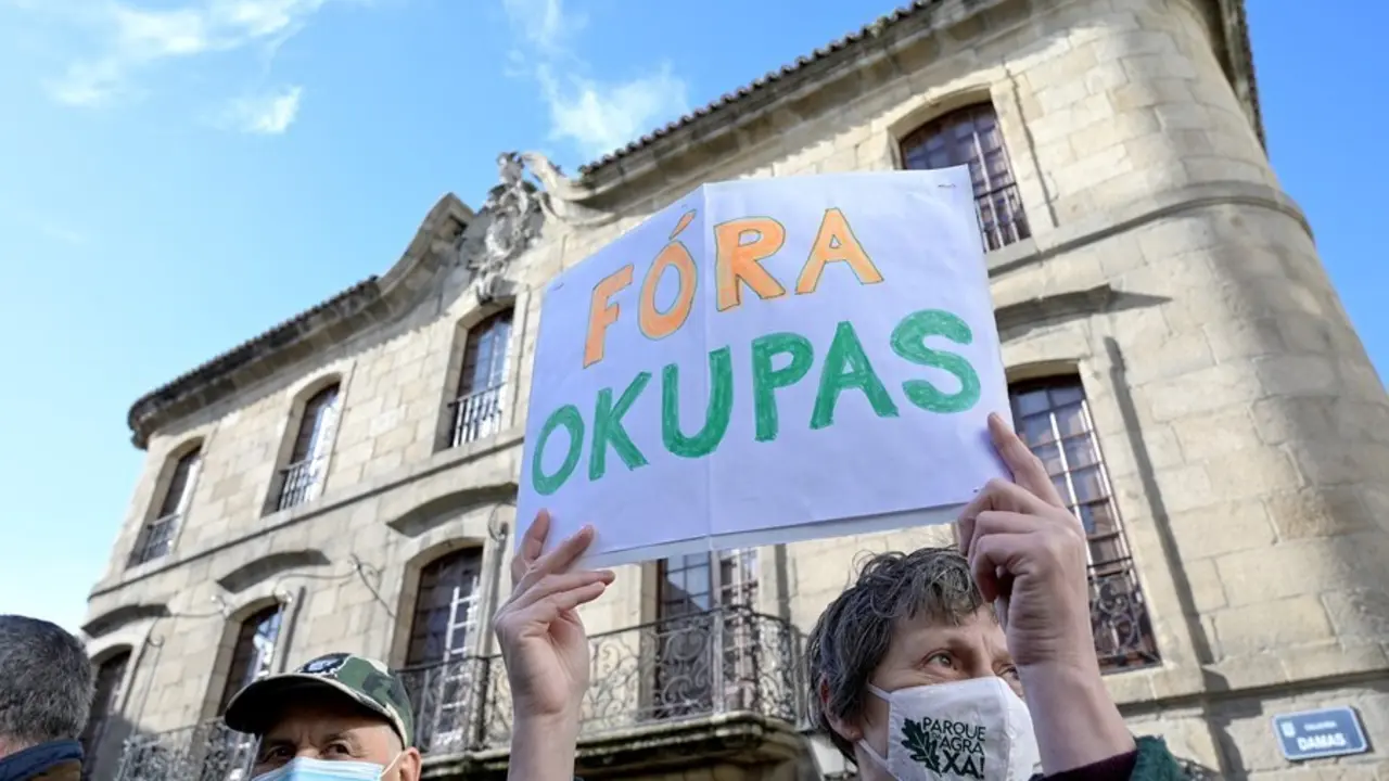 Archivo - Una persona sostiene un cartel donde se puede leer "Fuera okupas" durante la marcha c&iacute;vica para pedir la "devoluci&oacute;n" al patrimonio p&uacute;blico de la Casa Cornide, en manos de la familia Franco, en A Coru&ntilde;a, Galicia, (Espa&ntilde;a), a 7 de noviembre de 20