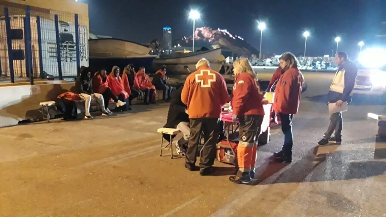 Archivo - Imagen de archivo de efectivos de Cruz Roja atendiendo en Alicante a personas llegadas a bordo de una patera 