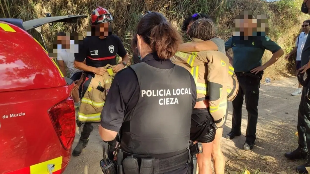 La mujer rescatada se abraza a una amiga una vez puesta a salvo