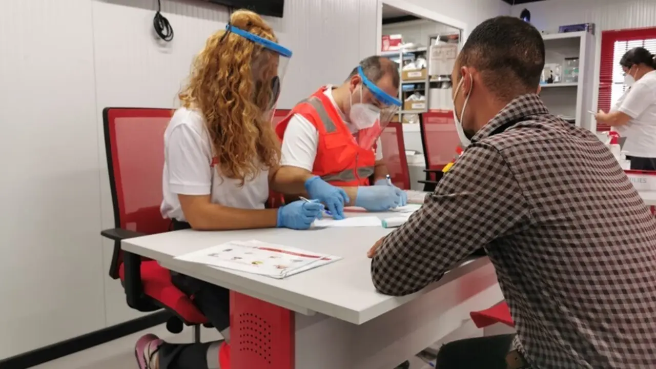 Voluntarios de Cruz Roja atienden a una de las 376 personas llegadas en patera a lo largo del fin de semana en Almer&iacute;a